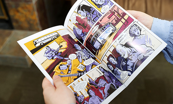 An open graphic novel showing five frames of action in shades of yellow, red and purple.