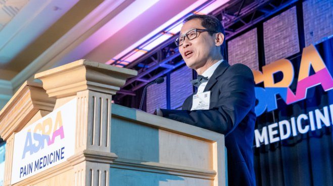 Dr. Ban Tsui speaks at a podium during the American Society of Regional Anesthesia and Pain Medicine awards.