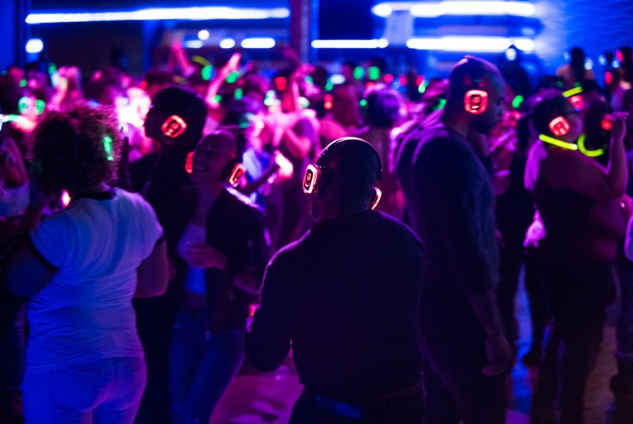 neon lights shining from heaphones during a silent disco