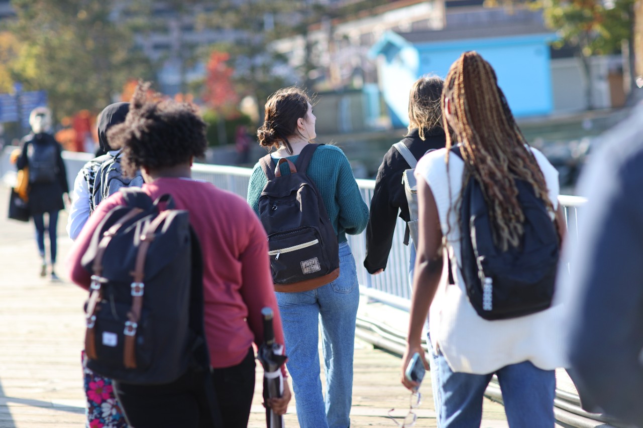 group of students wearing backpacks walking together