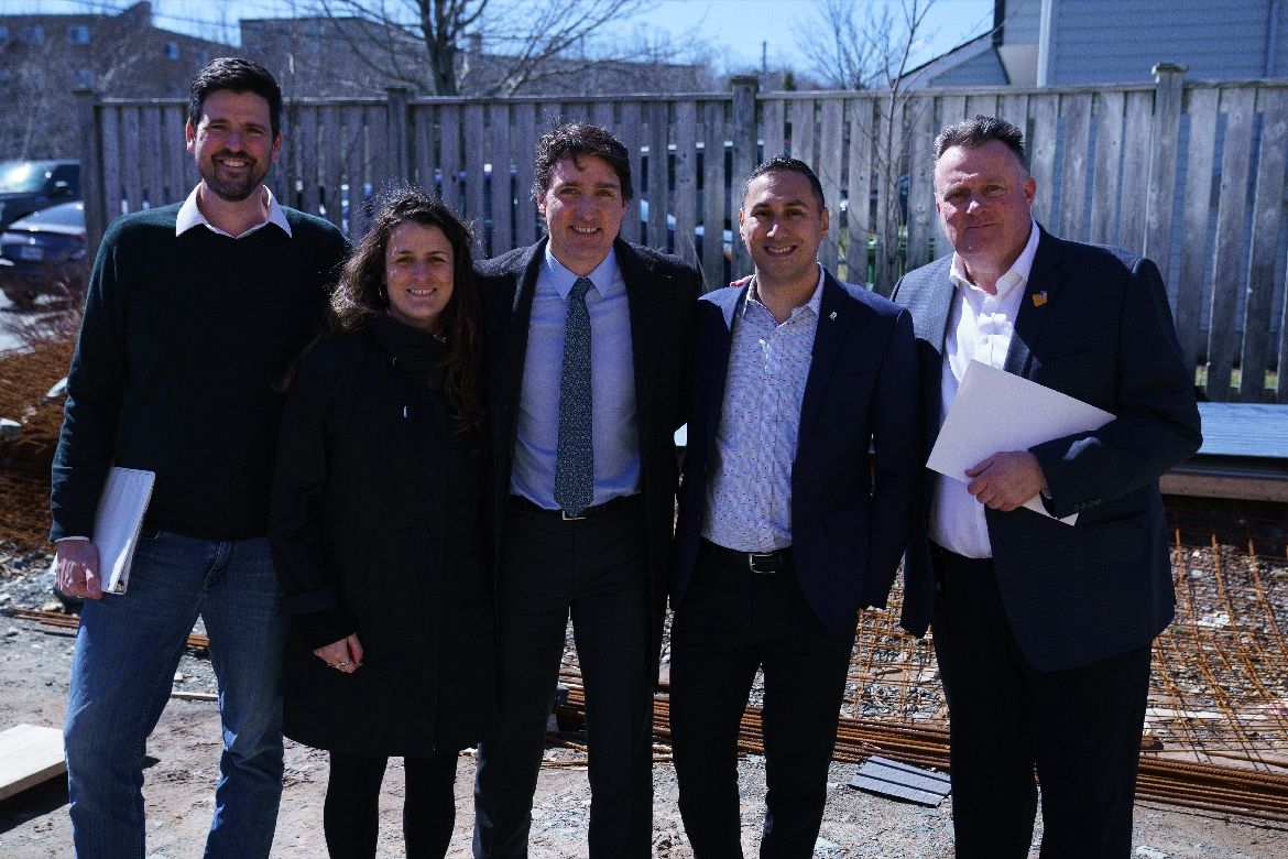 Kabalen posess with a group at an announcement event outdoors with Justin Trudeau and Mike Savage.