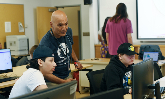 An instructor leads students in a workshop in a computer lab