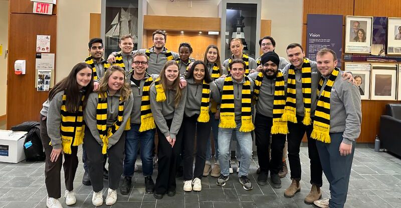A group of students wearing black and yellow scarves