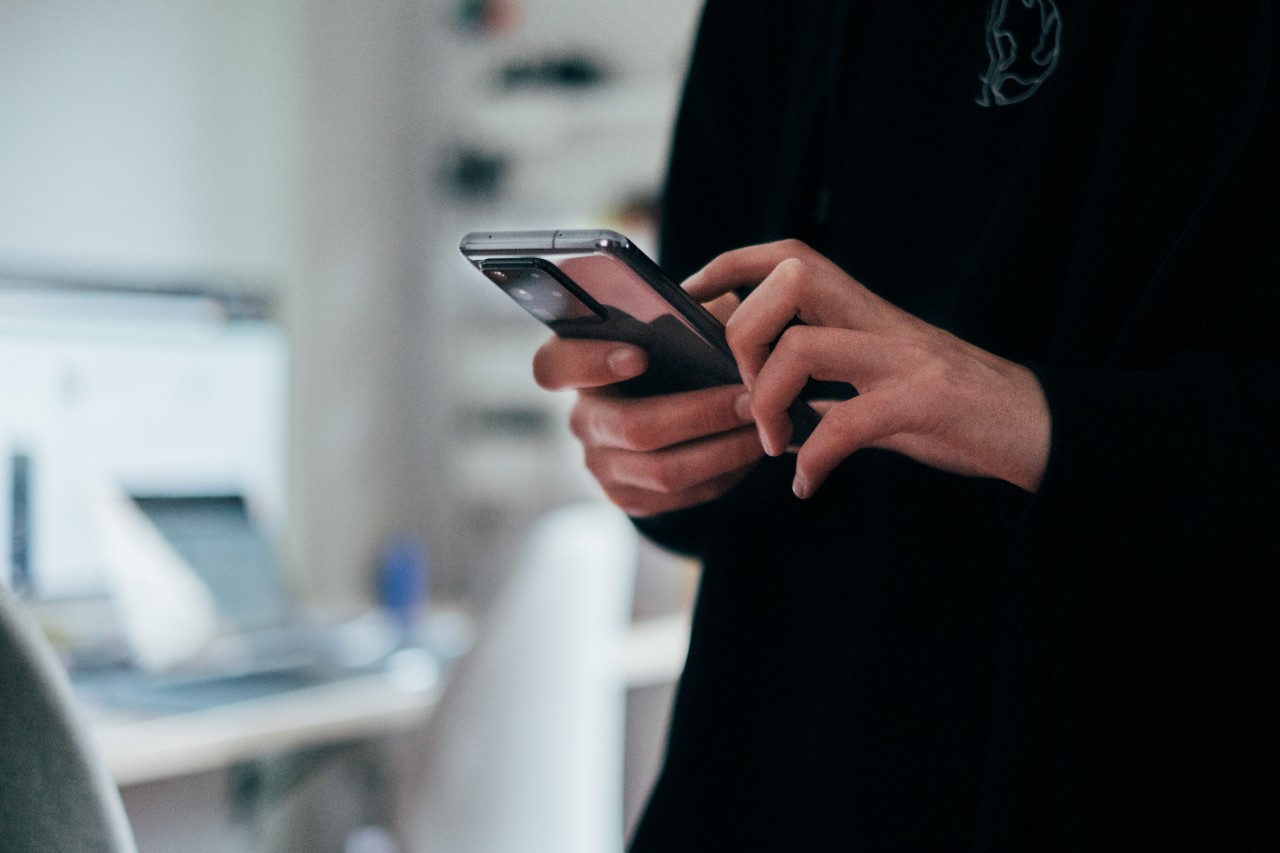 Close up of a woman wearing a black shirt using her mobile phone. 